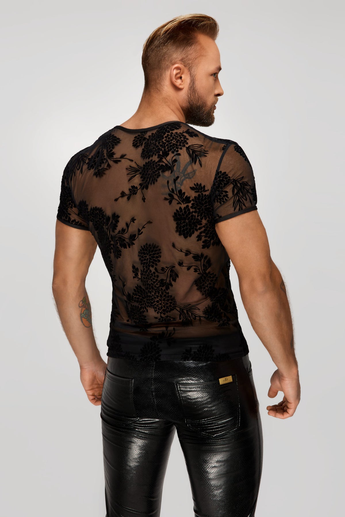 Men’s black floral flock T-shirt, rear three-quarter view.